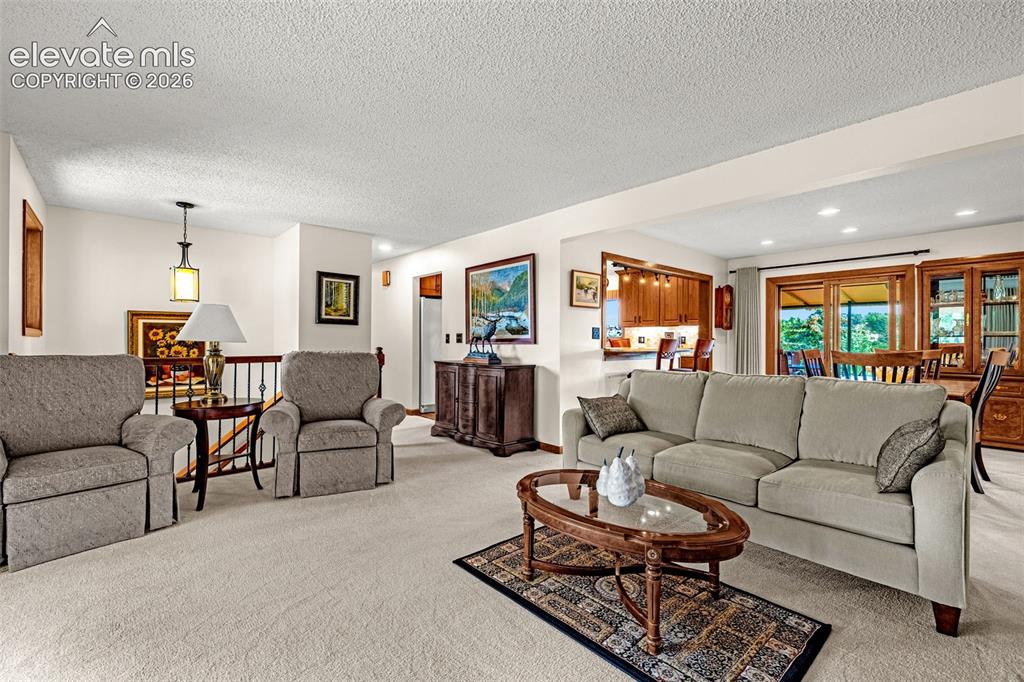 Image 8 of 42: Living room is open to dining room which also has walk-out to back deck