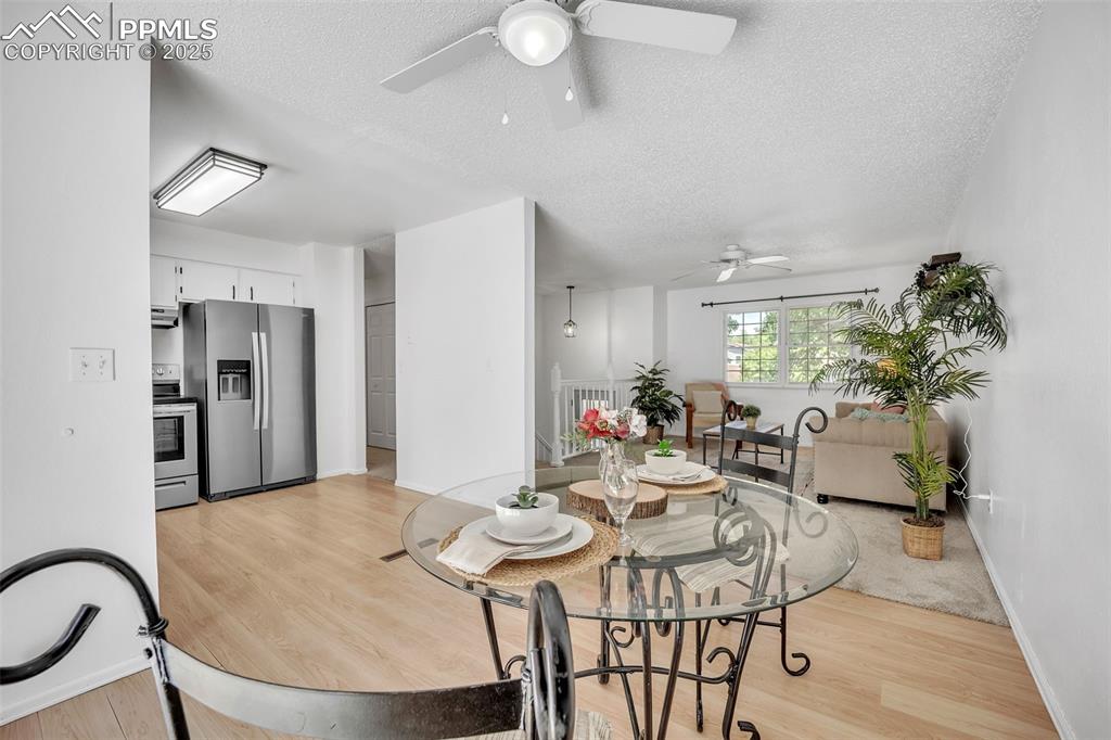 Image 11 of 34: Dining room featuring a textured ceiling, light wood-style floors, and a ce