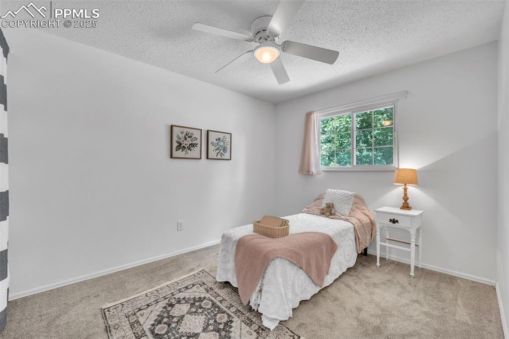 Image 20 of 34: Bedroom with carpet flooring, ceiling fan, and a textured ceiling