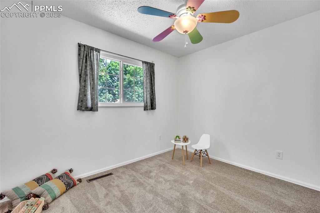 Image 21 of 34: Unfurnished room with carpet, a textured ceiling, and ceiling fan