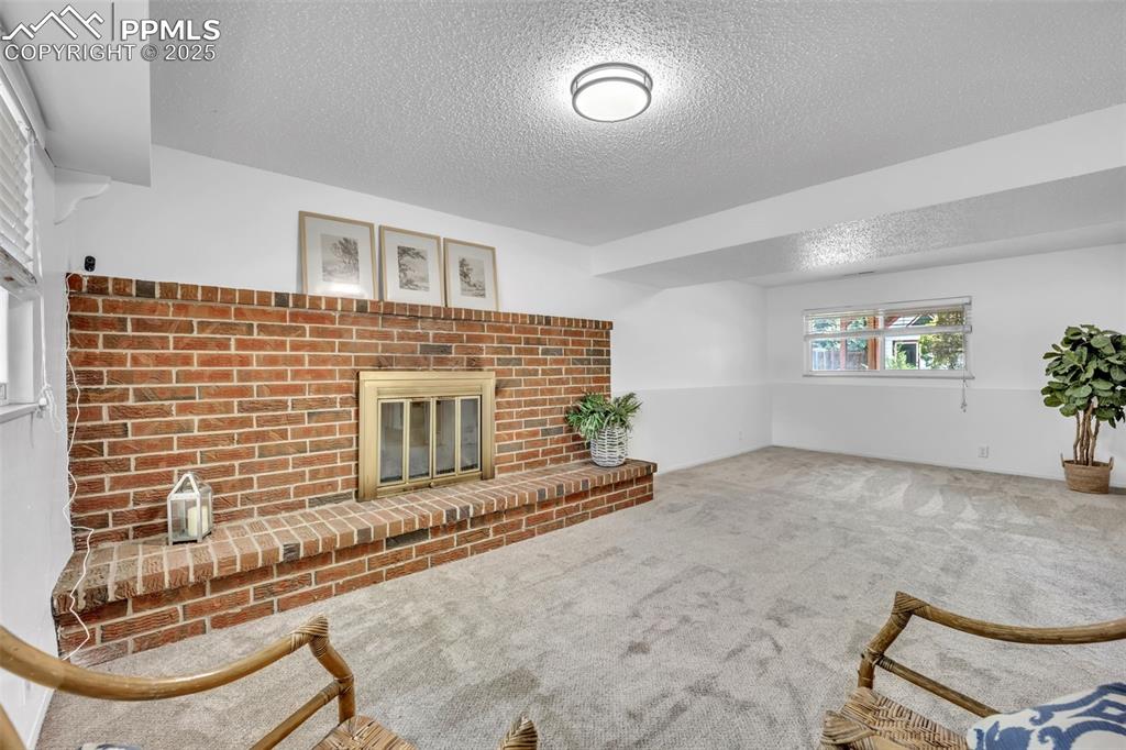Image 6 of 34: Lower Level large living room with fireplace.