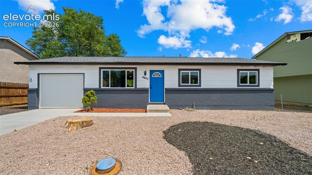 Caption: Single-story residence featuring a two-tone exterior, attached garage, and a vibrant blue entry door