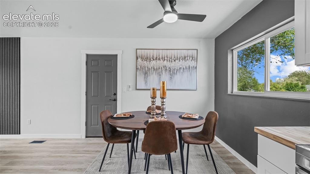 Image 10 of 31: Wood-finish flooring throughout, modern ceiling fan, dark accent wall, and 