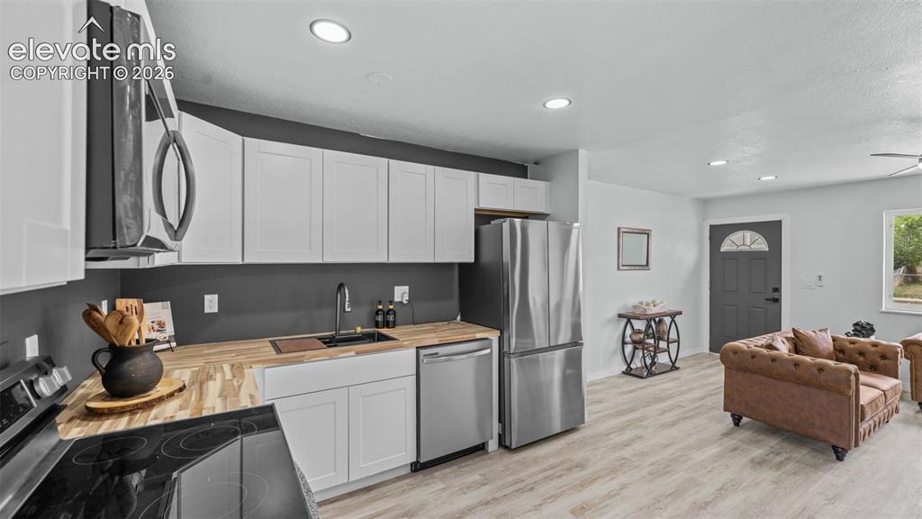 Image 13 of 31: Modern kitchen featuring stainless steel appliances, butcher block countert
