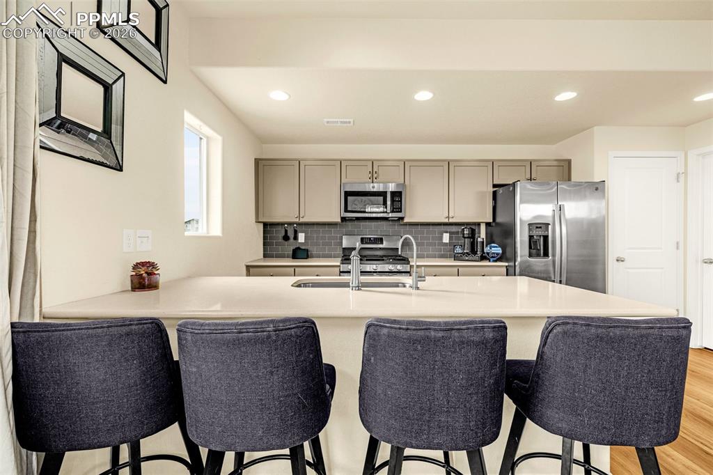 Image 11 of 33: kitchen offers breakfast bar with quarts counter top
