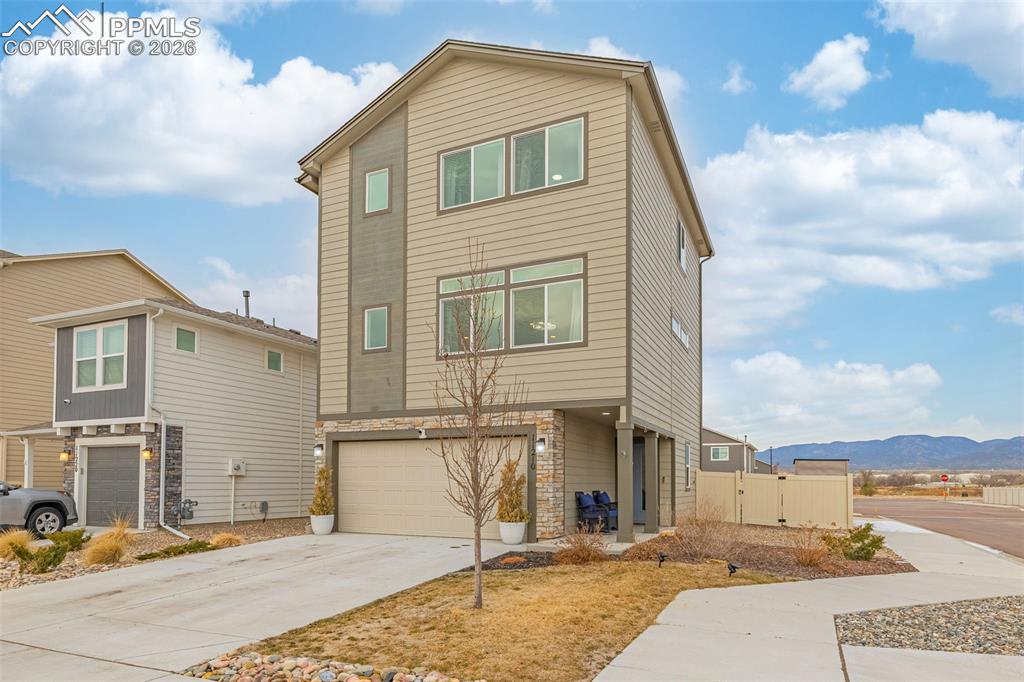 Image 2 of 33: Front of House with 2 Car Garage and mountain view in the horizon