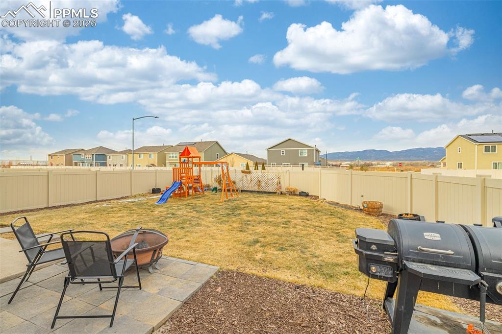 Image 27 of 33: Spacious back yard with grass and mountain views