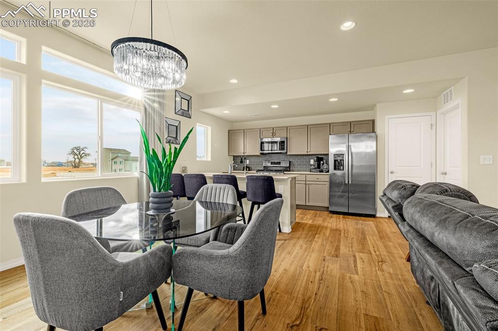 Image 9 of 33: Dining room with automatic blinds great for natural light when company is o