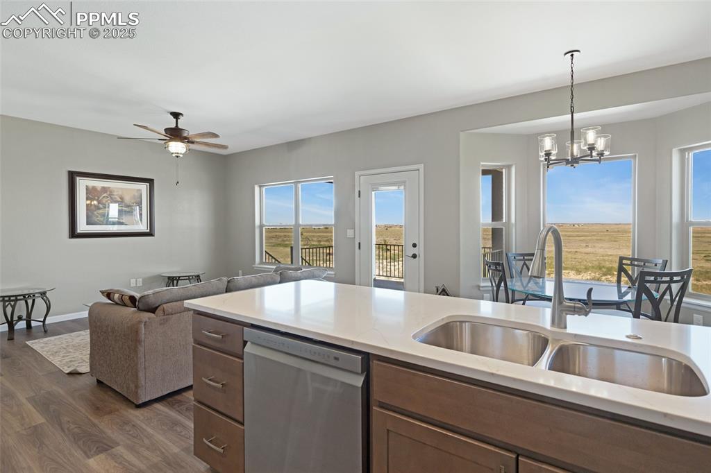 Image 10 of 41: Kitchen with stainless steel dishwasher, dark wood finished floors, open fl
