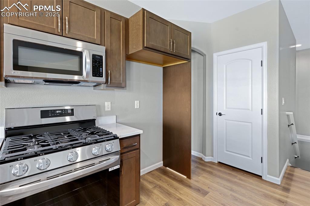 Image 12 of 41: Kitchen featuring stainless steel appliances, light wood finished floors, l