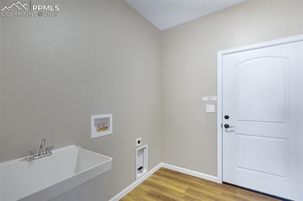 Image 13 of 41: Laundry room featuring light wood finished floors, hookup for a washing mac