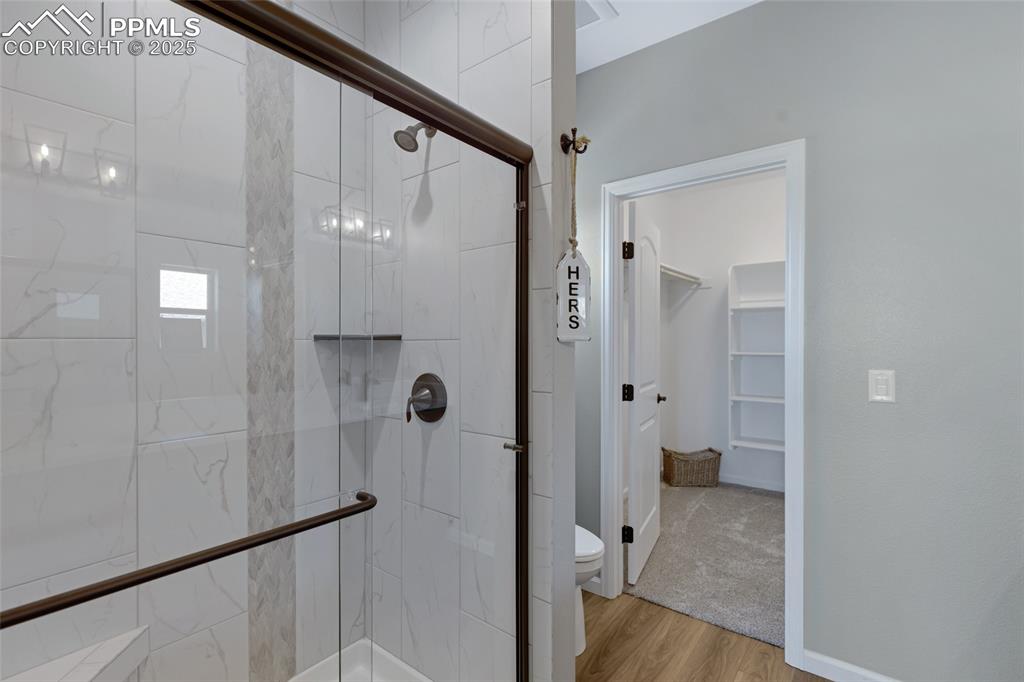 Image 17 of 41: Bathroom featuring a shower stall, light wood finished floors, and a spacio