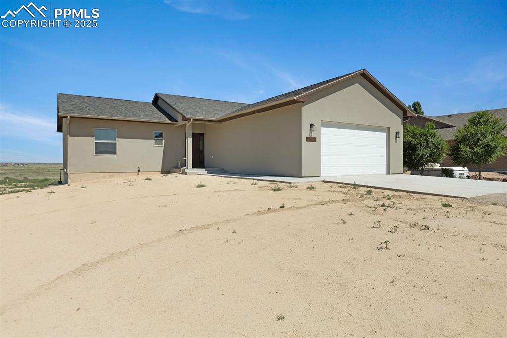 Image 3 of 41: Single story home with stucco siding, a shingled roof, an attached garage,