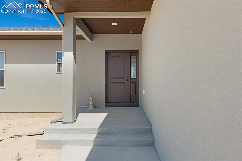Image 4 of 41: View of exterior entry featuring stucco siding and a porch