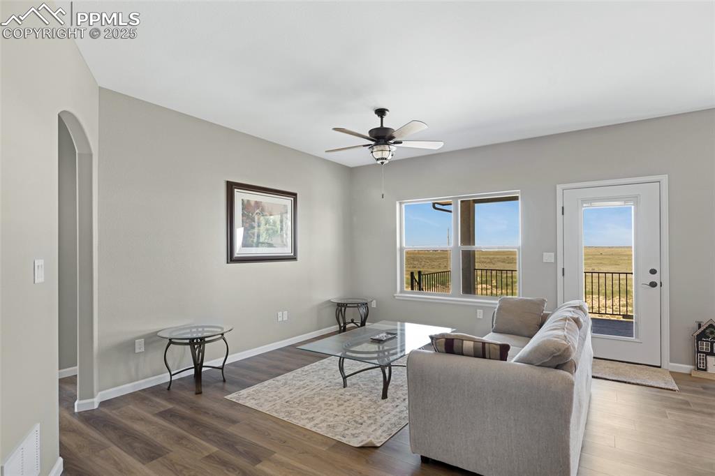 Image 6 of 41: Living room featuring wood finished floors, arched walkways, and a ceiling