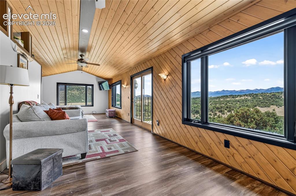 Image 14 of 45: Wood-finish flooring with an angled wood-paneled wall, vaulted wood-plank c