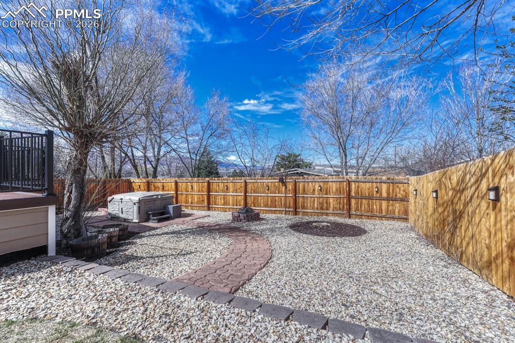 Image 18 of 50: Great landscaping with firepit and hot tub.