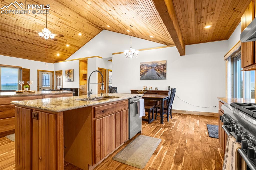 Image 16 of 48: Kitchen featuring brown cabinetry, appliances with stainless steel finishes