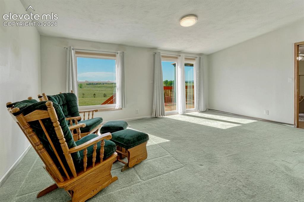 Image 22 of 50: main level primary bedroom with walkout to deck and incredible views of the