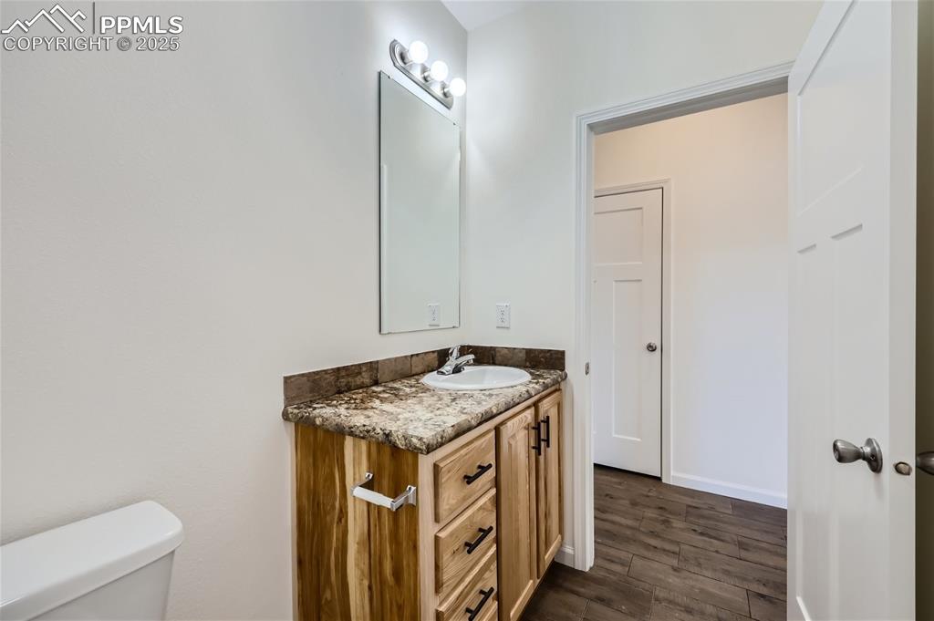 Image 13 of 16: Bathroom with vanity and dark wood finished floors