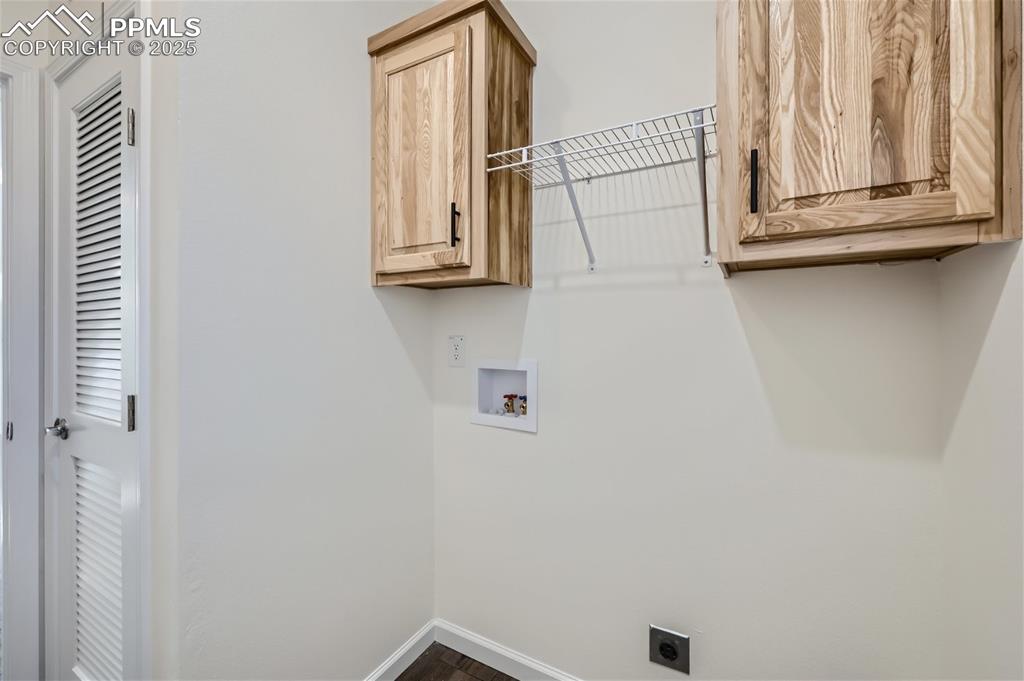 Image 16 of 16: Laundry area with cabinet space, dark wood-type flooring, washer hookup, an