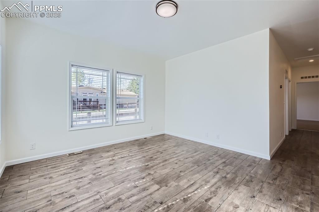 Image 3 of 16: Empty room with wood finished floors and baseboards