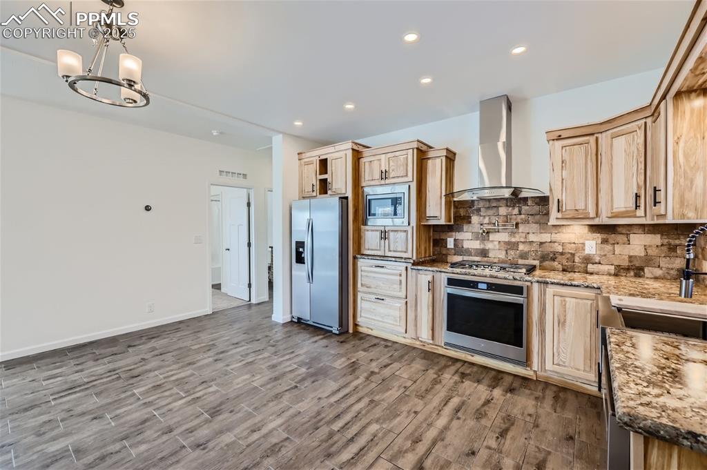 Image 9 of 16: Kitchen with light brown cabinets, backsplash, stainless steel appliances, 