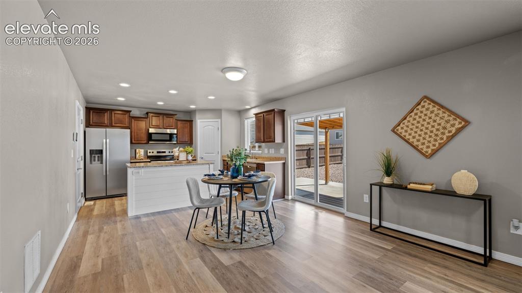 Image 11 of 43: Open-concept main living area featuring wood-finish flooring, recessed ligh