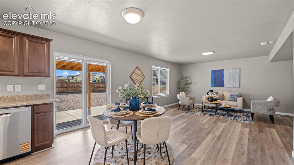 Image 13 of 43: Open-concept living space featuring wood-finish flooring, light gray walls,