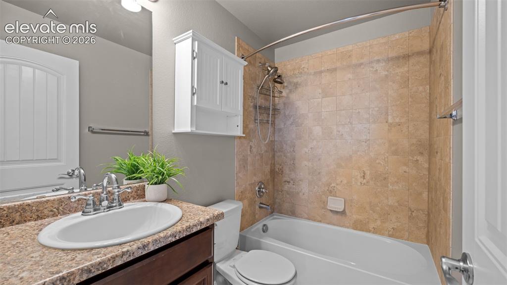 Image 19 of 43: Bathroom with a single vanity featuring a stone-finish countertop, undermou