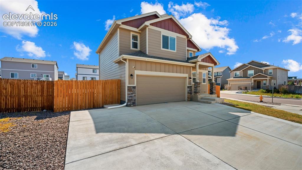Image 2 of 43: Two-story residence featuring composite siding and stone veneer accents
