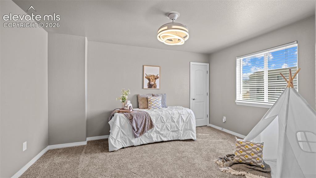 Image 20 of 43: Spacious secondary bedroom featuring soft gray walls, abundant natural ligh