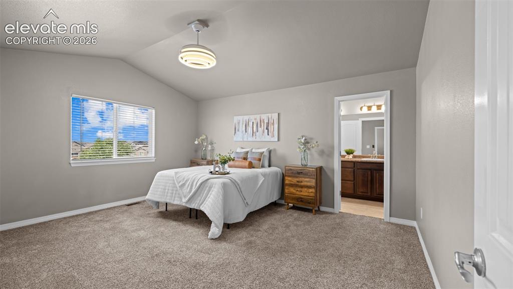 Image 22 of 43: Vaulted ceiling bedroom with carpet flooring, a window featuring horizontal