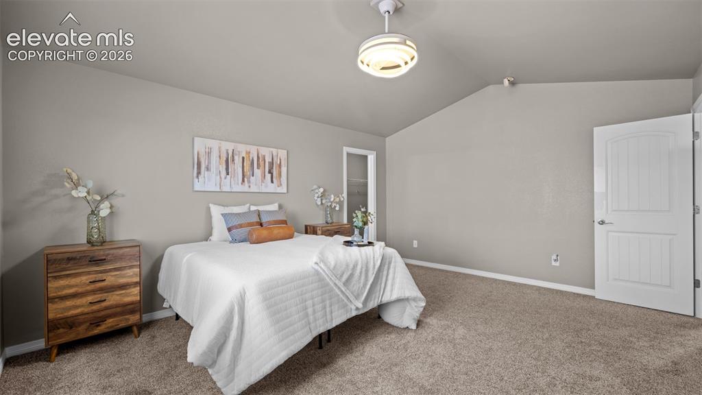 Image 23 of 43: Vaulted ceiling with a flush-mount light fixture, neutral carpet flooring,