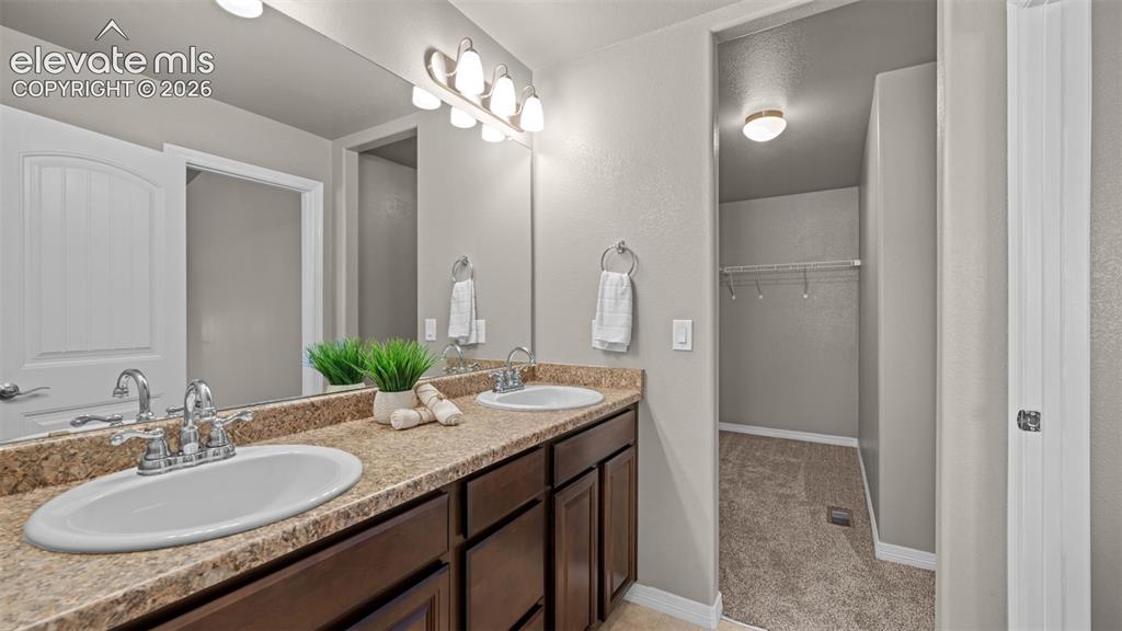 Image 26 of 43: Double vanity featuring white oval sinks, chrome faucets, and a light-toned
