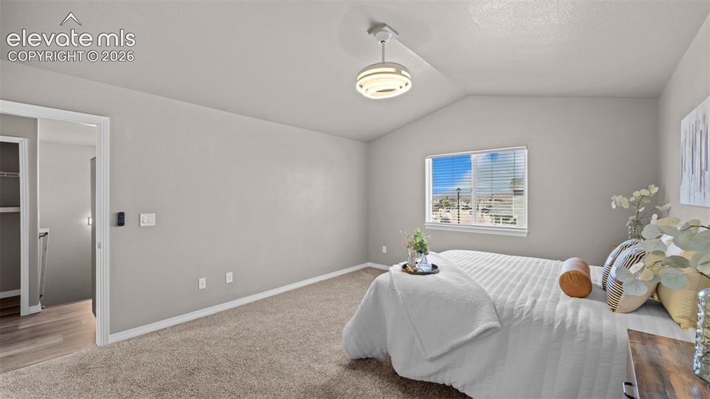 Image 28 of 43: Carpeted room featuring a vaulted ceiling and a rectangular window with hor