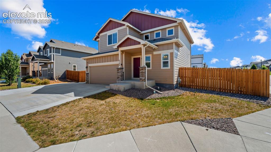 Image 3 of 43: Two-story residence featuring a covered front porch with stone accents, a t