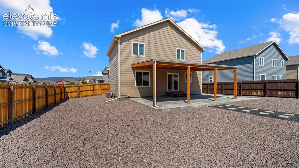 Image 31 of 43: Rear exterior featuring a covered patio with wood supports, sliding glass d