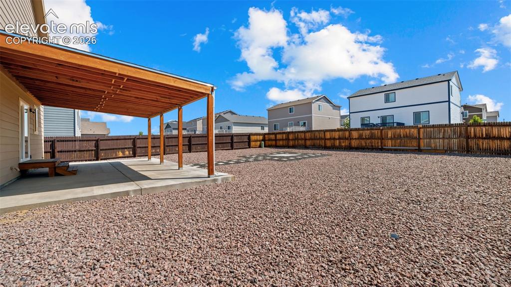 Image 32 of 43: Expansive backyard featuring a covered patio with a wood-finish ceiling, co