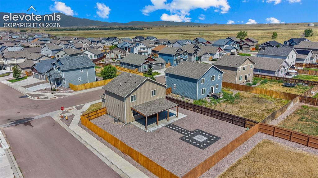 Image 37 of 43: Two-story residence featuring a covered patio, fenced yard with gravel land
