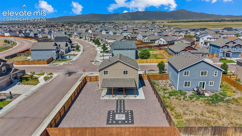 Image 38 of 43: Two-story residence with a covered patio overlooking a gravel yard with a p