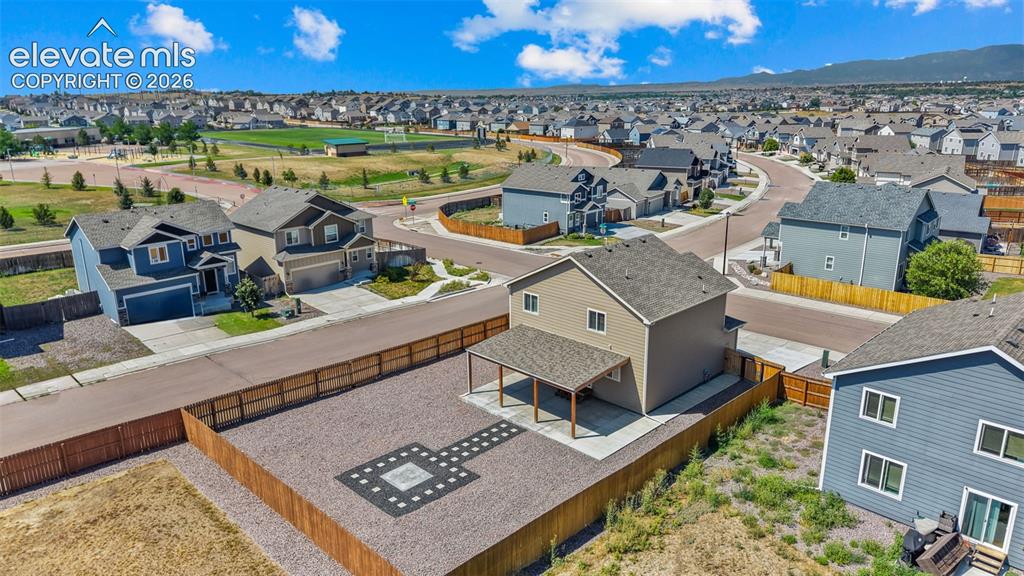 Image 39 of 43: Two-story residence featuring a covered patio, fenced backyard with a paver