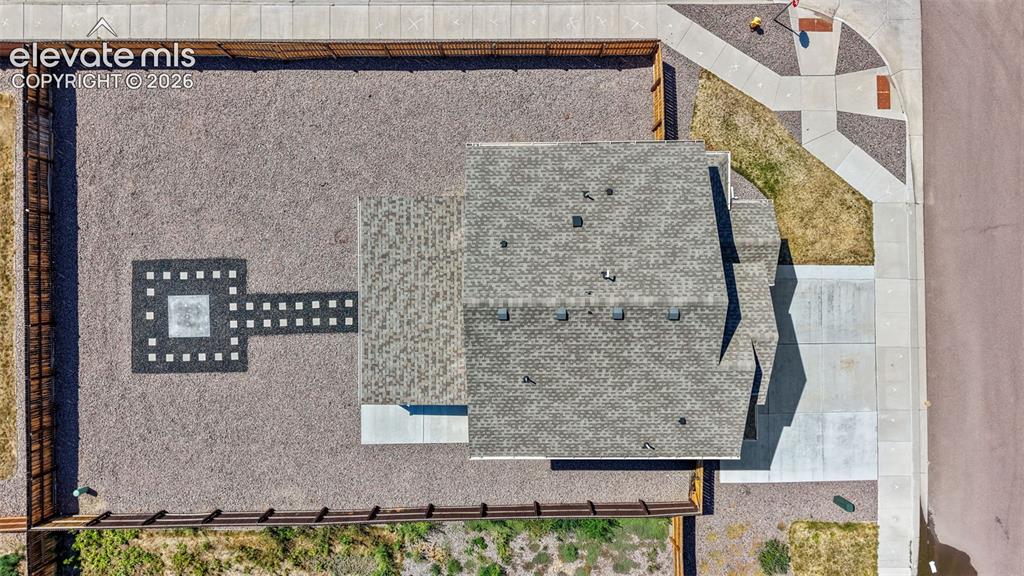 Image 40 of 43: Expansive gravel yard featuring a unique geometric paver design