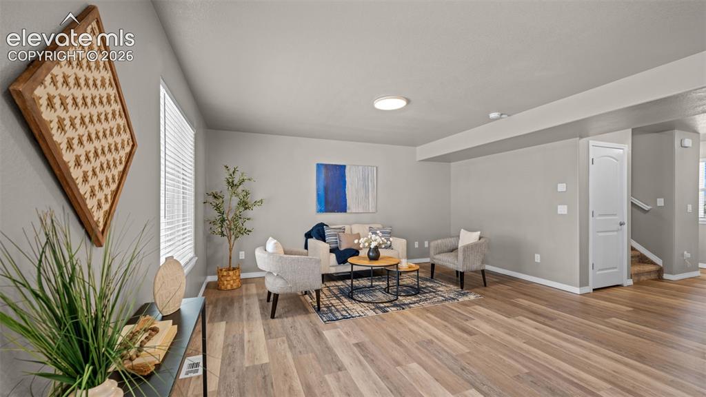 Image 9 of 43: Spacious living area featuring wood-finish flooring, light gray wall tones,