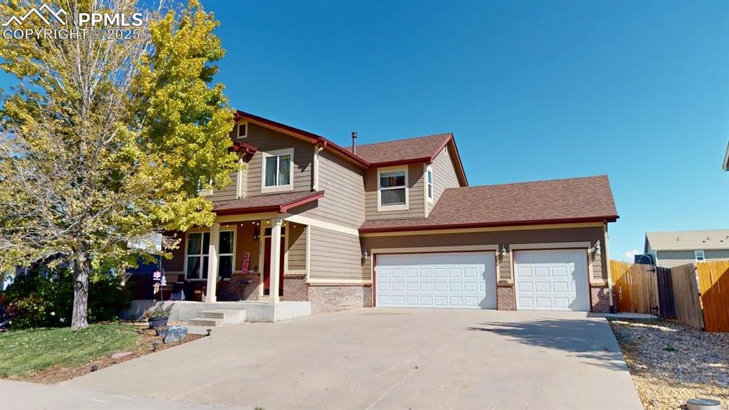 Image 1 of 14: View of front of home with a porch, roof with shingles, driveway, brick sid