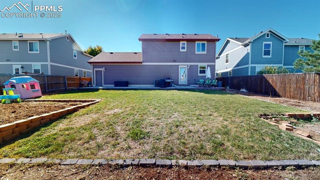 Image 4 of 14: Rear view of house featuring a patio area and a fenced backyard