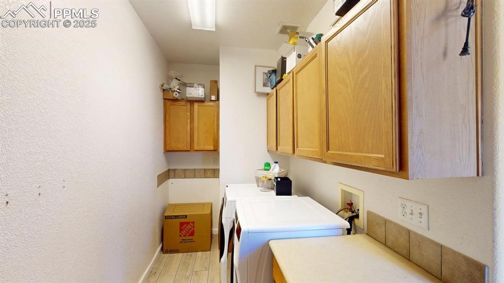 Image 9 of 14: Laundry room with cabinet space, light wood-type flooring, washer and dryer