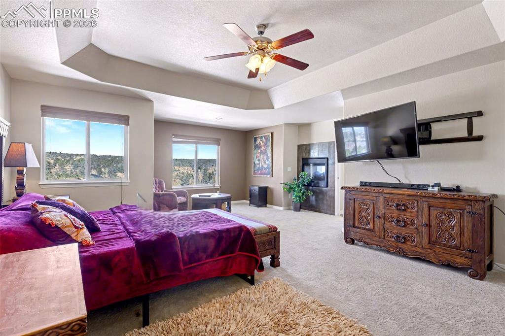 Image 20 of 43: Primary bedroom complete with sitting area and double- sided fireplace!