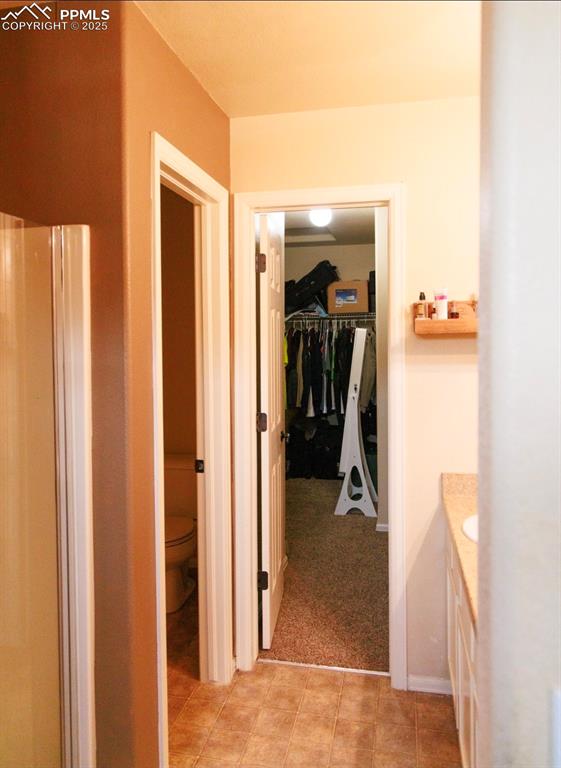 Image 15 of 21: Hall with light colored carpet and light tile patterned flooring