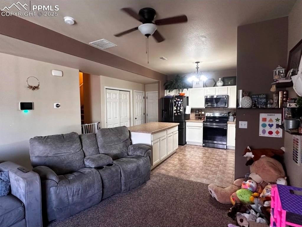 Image 9 of 21: Living room featuring a ceiling fan and carpet flooring